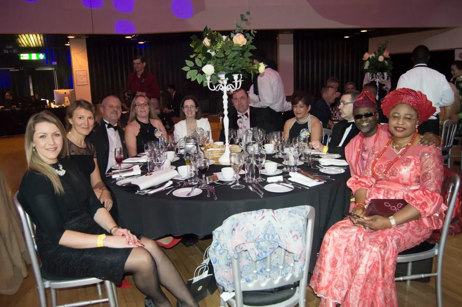 Guests smiling around a candlelit dinner table